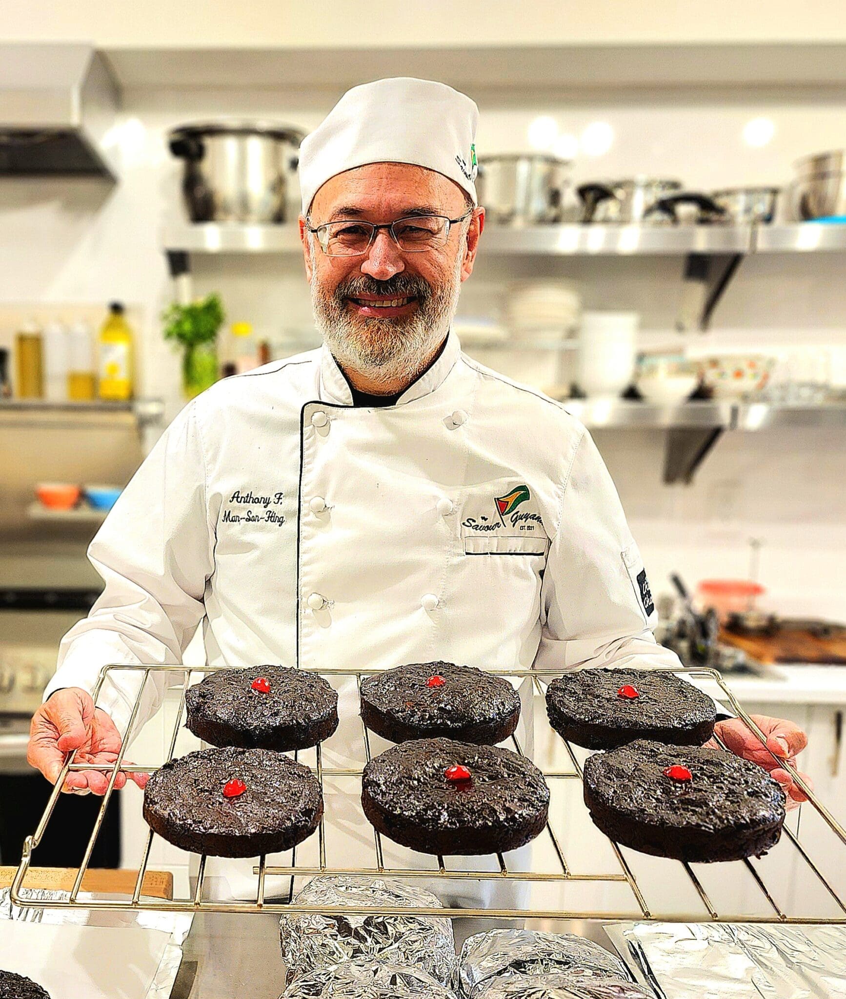 Chef holding chocolate cakes in kitchen.